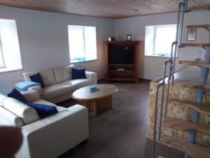 ein Wohnzimmer mit einem Sofa und einem Tisch in der Unterkunft Jurahaus Maisonette Wohnung in Solnhofen