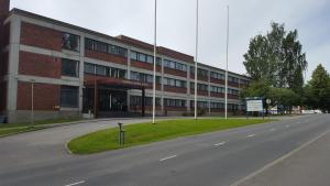 duży ceglany budynek z drogą przed nim w obiekcie Economy Hotel Savonia w mieście Kuopio