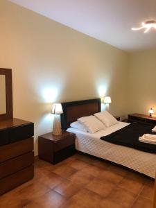 a bedroom with a bed with two night stands and two lamps at Berço Funchal in Funchal