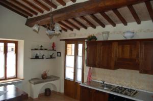 a kitchen with wooden cabinets and a sink at Agriturismo Podere Ranciano Alto in Castiglione del Lago