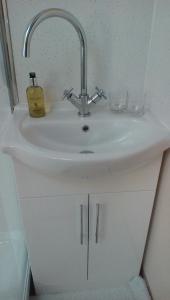 a bathroom sink with a faucet and two glasses at The Lincolnshire Poacher Inn in Metheringham