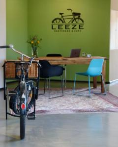 a bike parked in front of a table with a laptop at Gästehaus & Café Leeze in Bad Dürkheim