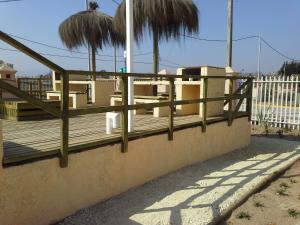 una valla de madera en una pared con palmeras en La Serena Viajes, en La Serena