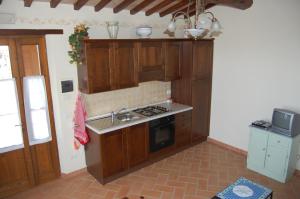 a kitchen with wooden cabinets and a stove top oven at Agriturismo Podere Ranciano Alto in Castiglione del Lago +13 photos