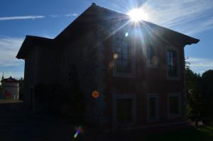 una casa con el sol brillando encima de ella en Complejo turístico Quinta La Espadaña en Bedriñana