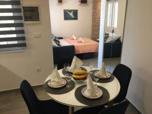 a dining room with a table and chairs and a bed at Paradise Stone Apartments in Bol