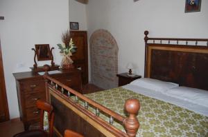 a bedroom with a wooden bed and a wooden dresser at Agriturismo Podere Ranciano Alto in Castiglione del Lago