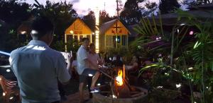 a group of people standing around a fire in a yard at Garden Homestay in Di Linh