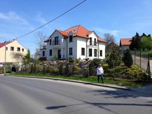 eine Person, die eine Straße vor einem Haus entlang geht in der Unterkunft Apartament WIKA in Wieliczka