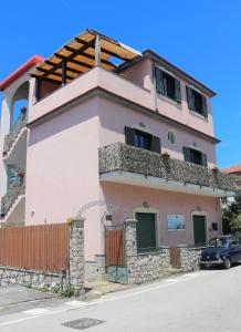 a pink house with a car parked in front of it at Casa Vacanze Il Postino in SantʼAgata sui Due Golfi