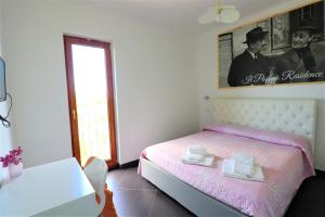 a bedroom with a pink bed with two towels on it at Casa Vacanze Il Postino in SantʼAgata sui Due Golfi +38 photos