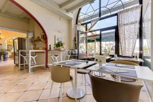 a restaurant with tables and chairs and a large window at Hôtel de la Citadelle in Sisteron