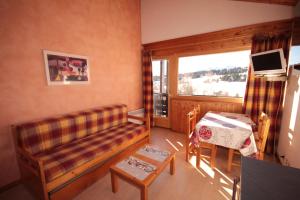 a living room with a couch and a window at Appt 4/5 pers. Les Saisies front de neige in Les Saisies