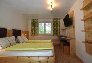 a bedroom with a bed and a desk and a window at Gasthaus Schöberingerhof in Weyregg