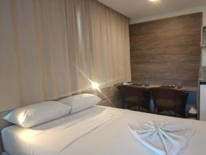 um quarto de hotel com uma cama e uma mesa com cadeiras em MARULHOS RESORT - STÚDIOS TEMPORADA em Porto de Galinhas