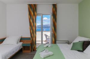 a bedroom with two beds and a view of the ocean at Downtown Private Rooms Mandić in Supetar