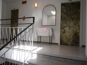 Zimmer mit einer Treppe und einem Stuhl mit einem Spiegel in der Unterkunft Hotel Walter in Gatteo a Mare