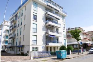 un edificio blanco con balcones en una calle en CONDOMINIO SATURNO, en Lido di Jesolo