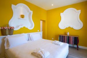 Un dormitorio con una cama blanca con paredes amarillas en Appartamento Suite Melina, en Praiano