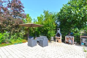 une terrasse avec un parasol, des chaises et une table dans l'établissement Apartments Vili 351, à Fažana