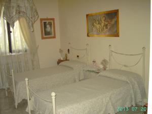 a bedroom with three white beds and a window at Villa Nicolaus in Bari