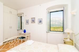 Stone House DiMaTo في Gruda: غرفة نوم بيضاء بها سرير ونافذة