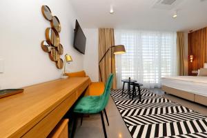 a bedroom with a bed and a desk with a green chair at White Rooms Zadar345 in Zadar