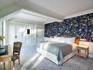 a bedroom with a bed and a desk and a chair at Le Meurice – Dorchester Collection in Paris
