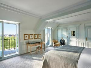a bedroom with a bed and a desk and a window at Le Meurice – Dorchester Collection in Paris