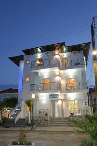 a large white building with stairs in front of it at Hotel Anna in Skala Potamias