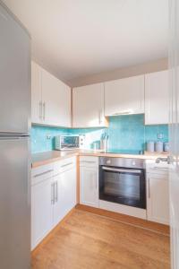 a kitchen with white cabinets and a stainless steel appliance at Ground Floor West End /City Centre / Rockvilla flat & Parking in Glasgow