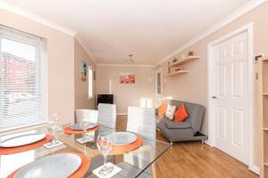 Una sala de estar con una mesa de cristal y sillas. en The Cluthar - Ground Floor West End City Centre Rockvilla flat & Parking, en Glasgow