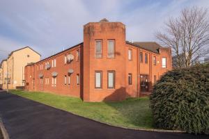 un edificio de ladrillo con una torre en el lateral de una calle en The Cluthar - Ground Floor West End City Centre Rockvilla flat & Parking, en Glasgow