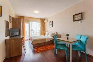 a hotel room with a bed and a table and chairs at La Casa Primorsko in Primorsko