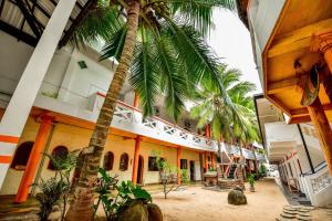 a palm tree in the middle of a building at International Beach Hotel & Restaurant in Hikkaduwa