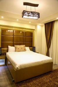 a bedroom with a large bed with a large headboard at Villa 14 Suites in 6th Of October