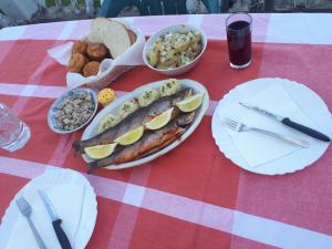 a table with plates of food on a red and white table cloth at Uvacko jezero (Uvac Lake) in Nova Varoš
