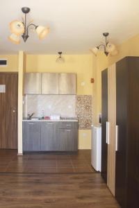 a large kitchen with a sink and a refrigerator at Horizont Apartments in Sunny Beach