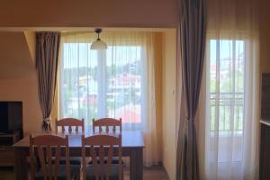 comedor con mesa, sillas y ventana en Horizont Apartments, en Sunny Beach