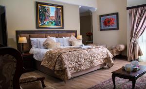 a bedroom with a large bed and a table at Casa Flora Guesthouse in Pretoria