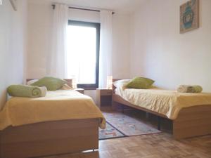 two beds in a room with a window at Apartment Irene in Pula