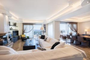 a living room with two white couches and a table at SeaRene Deluxe Seafront Maisonette in Ixia