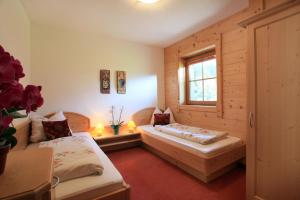 a bedroom with two beds and a window at Gasthaus Obergaisberg in Kirchberg in Tirol