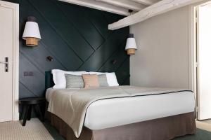 a bedroom with a large bed with a green wall at Hotel Bastille Speria in Paris