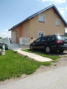 Rooms Josip في كورينيتسا: سيارة سوداء متوقفة أمام منزل