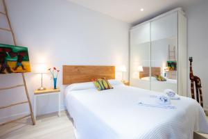 um quarto com uma grande cama branca e uma escada em Sustraia - Local Rentss em San Sebastián