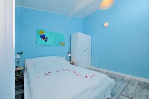 una camera da letto con un letto bianco con fiori rossi di Villa My Sunshine Star a Murter