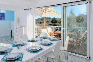 una sala da pranzo bianca con tavolo e sedie di Villa My Sunshine Star a Murter
