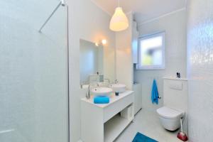 un bagno bianco con lavandino e WC di Villa My Sunshine Star a Murter Altre 42 foto
