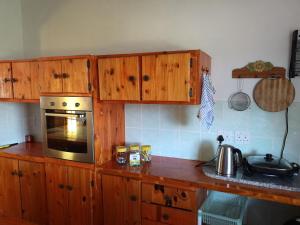 una cocina con armarios de madera y microondas en una encimera en The View Holiday Home, en Graskop